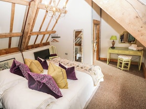 Ein Schlafzimmer mit Bett, Schreibtisch, Stuhl, Heizkörper und Spiegel.