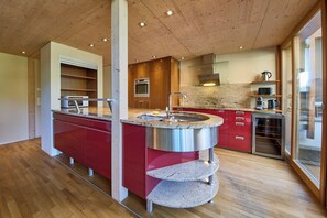 Eine moderne Küche mit Holzboden, integrierten Geräten und einer Arbeitsplatte aus Granit.