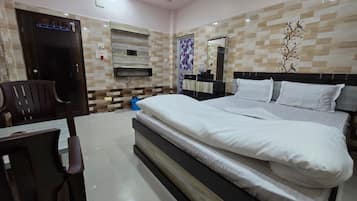 Habitación de hotel con una cama grande, un escritorio, una silla y un armario.