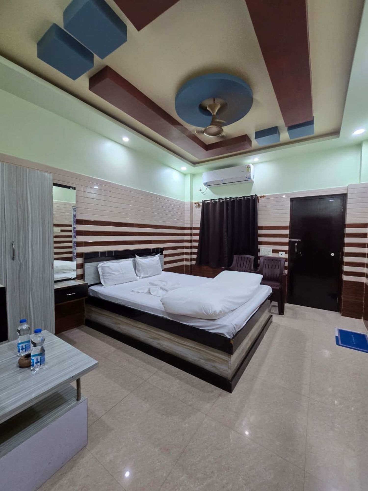 Una habitación de hotel con cama, mesita de noche y armario.