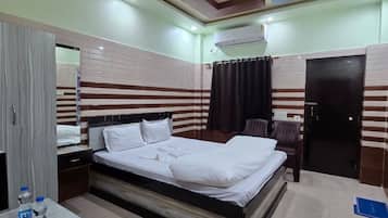 Una habitación de hotel con cama, mesita de noche y armario.