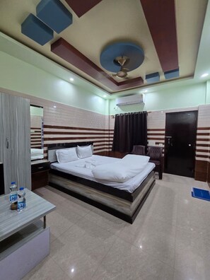 Une chambre d’hôtel avec un lit, une table de chevet et une armoire.