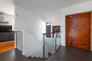 Ein modernes Interieur mit einer Treppe, einer Küchenzeile und einer Holztür.
