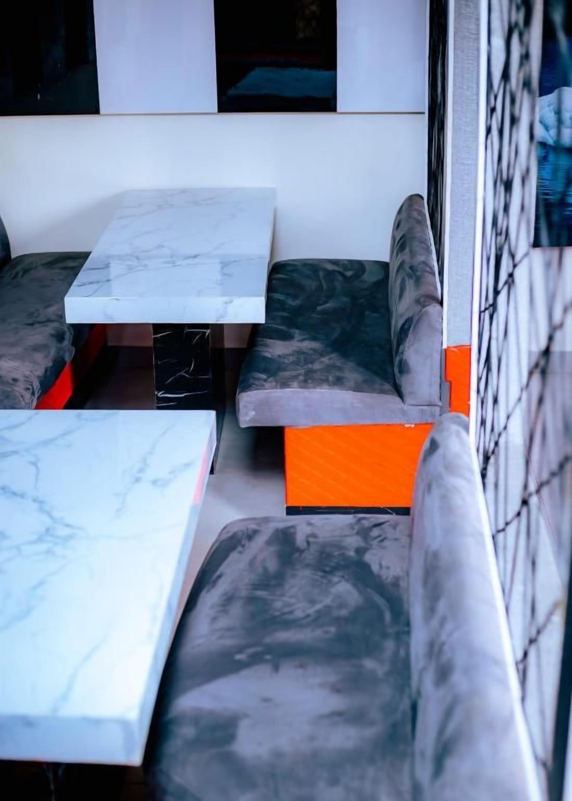 Un espace détente avec une table en marbre et des bancs rembourrés.