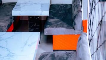 Un espace détente avec une table en marbre et des bancs rembourrés.