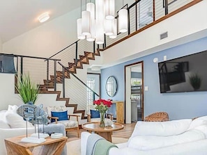 A spacious living room with a staircase, a dining area, and a large window. - Paradise Calling Florida (Monroe County)