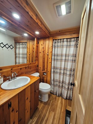 A wooden bathroom with a sink, toilet, and shower curtain. - Camp Jay Cloud - Views of the slopes! 4 bedroom 2 bath 
VAST trails! (Jay)