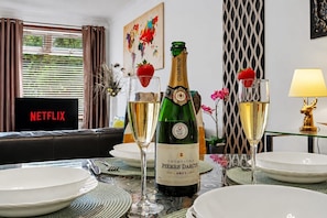 A dining table set with plates, glasses, and a bottle of champagne. - Easy London Links | Tottenham Stadium | Drumsheds (Greater London)