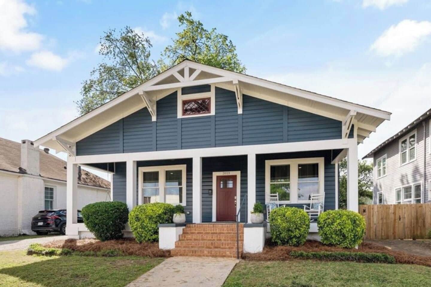 A two-story house with a front porch, a garage, and a well-maintained lawn.