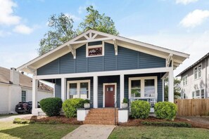 A two-story house with a front porch, a garage, and a well-maintained lawn.