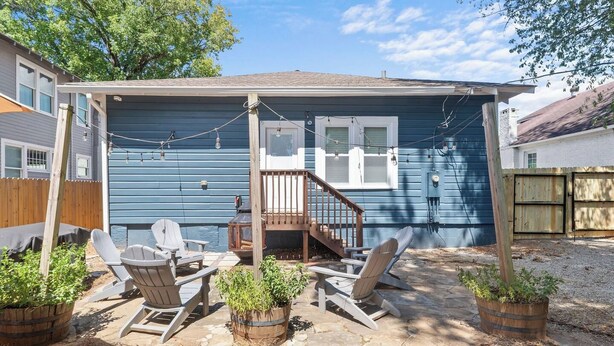 A blue house with a covered patio, wooden deck, and outdoor seating. - Fourth & Tide on 8th• Walk • Stay • Roll Tide (Tuscaloosa)