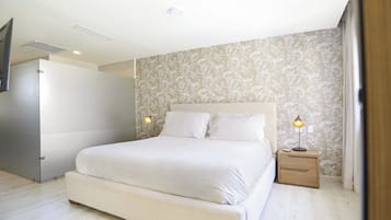 Un dormitorio con una cama grande, lámparas de noche y un papel tapiz estampado.