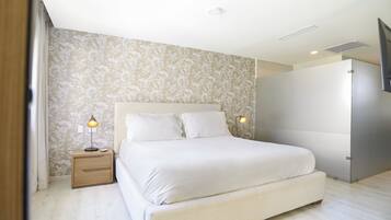 A modern bedroom with a large bed, two bedside lamps, and a patterned wallpaper.