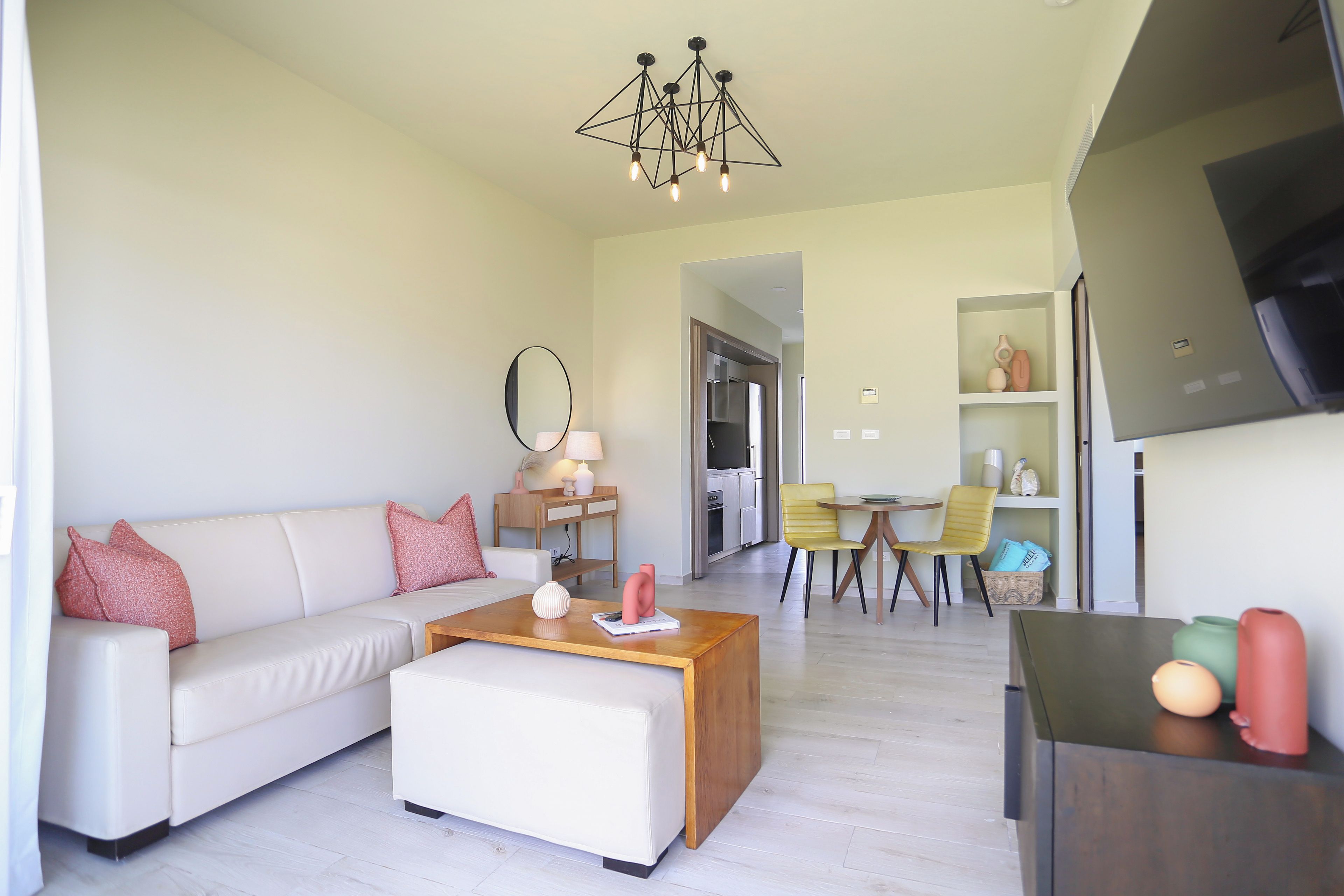 Un salon moderne comprenant un canapé, une table basse et un coin repas avec des chaises.