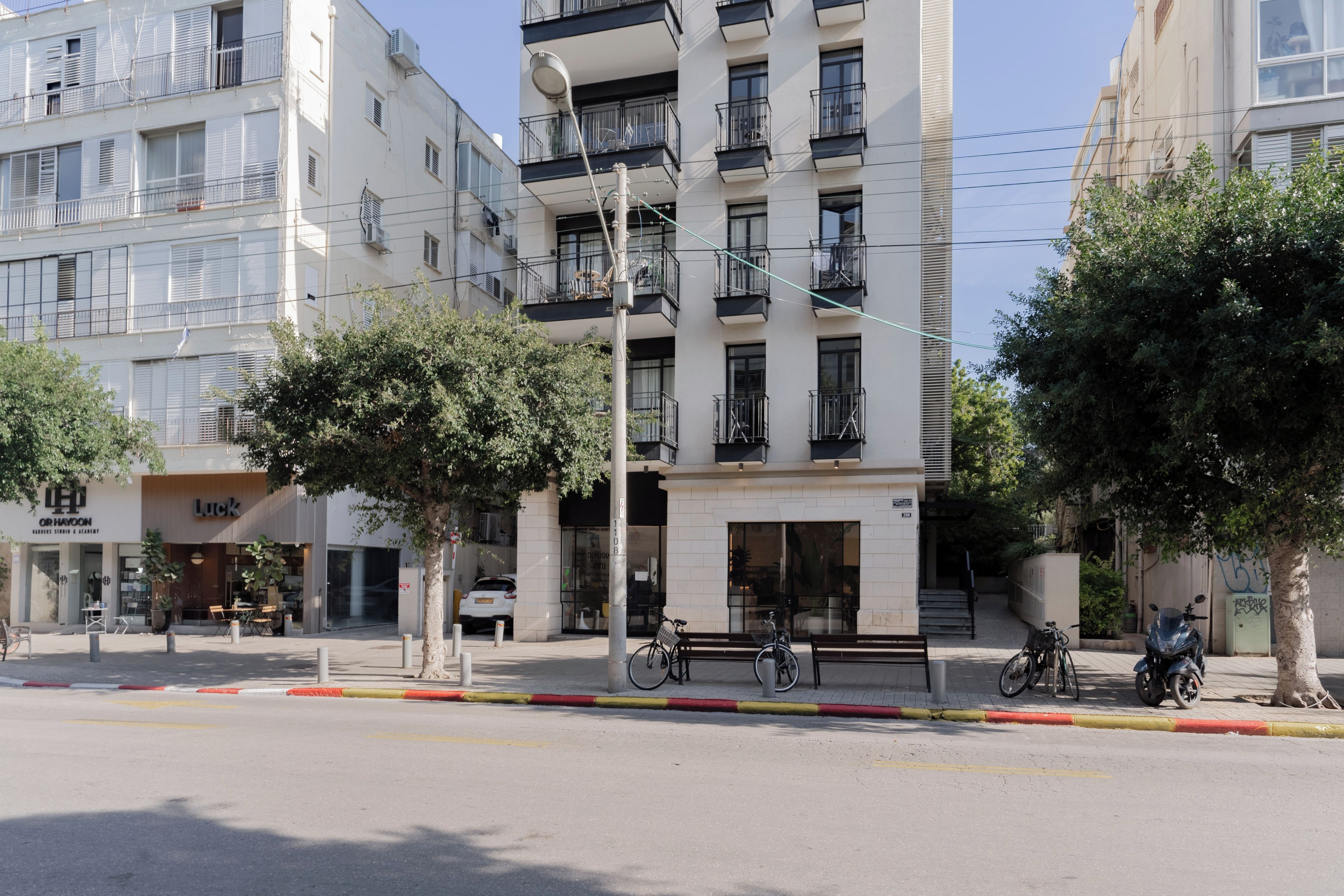 A multi-story building with balconies, a storefront, and parked bicycles.