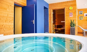 A modern indoor swimming pool with a wooden interior, a blue door, and a clock on the wall. - L ESTIBERE (Vielle-Aure)