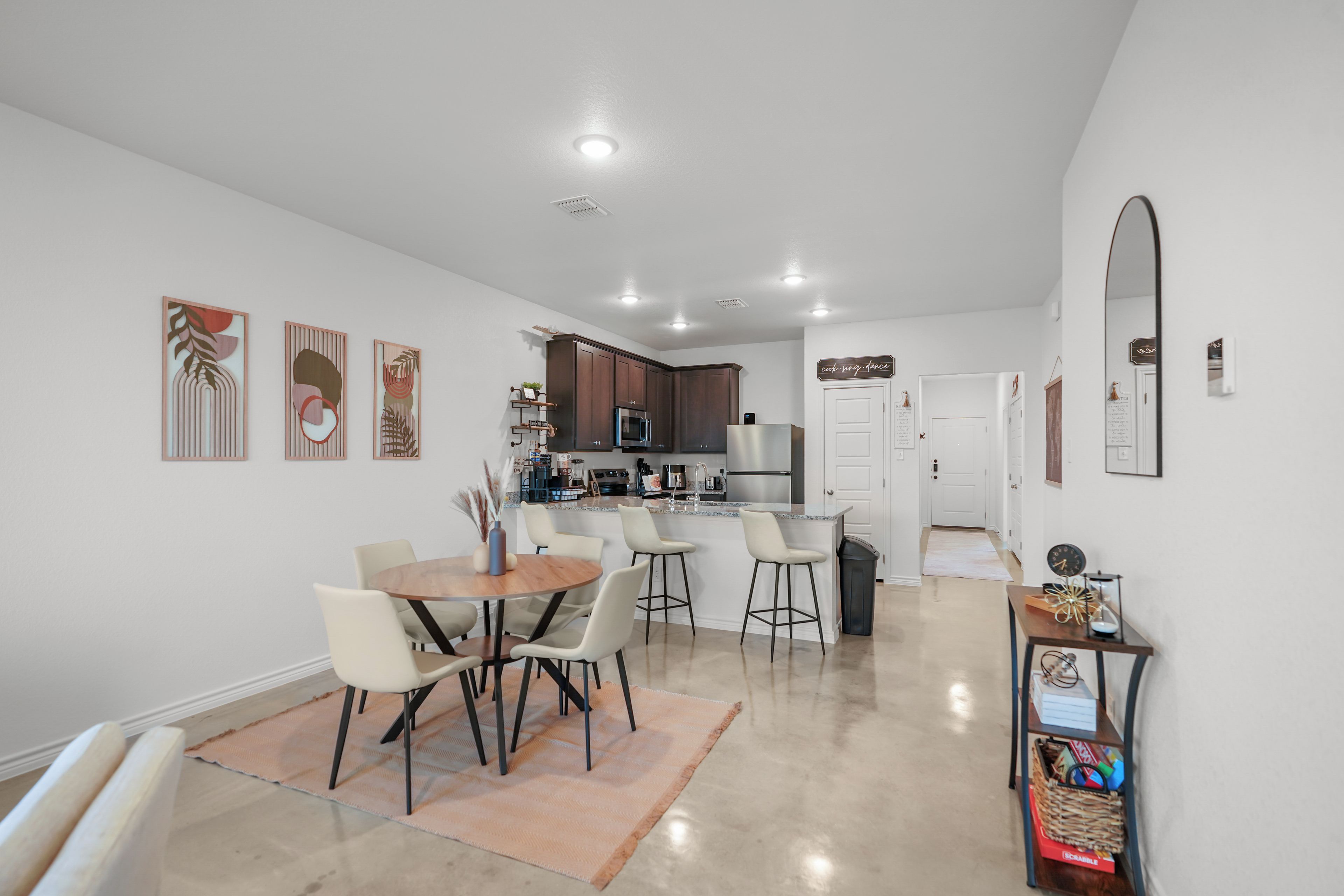 Una cocina moderna con armarios oscuros, un refrigerador de acero inoxidable y un microondas.
