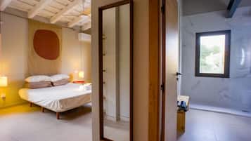 Une chambre à coucher avec un lit, des lampes de chevet et un grand miroir.