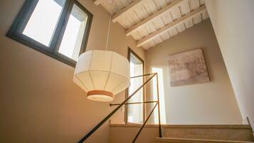 Un escalier avec un luminaire suspendu et un tableau accroché au mur.