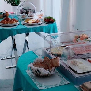 A breakfast buffet with various food items and a clear glass display case.
