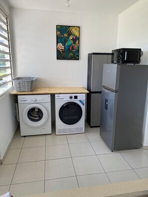 A compact laundry area with a washing machine, dryer, and a refrigerator. - Just like at home!! A quiet and pleasant apartment with a balcony overlooking the forest (none)