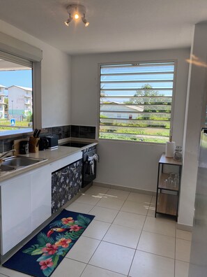 A compact kitchen with a window, a sink, a stove, and a small countertop. - Just like at home!! A quiet and pleasant apartment with a balcony overlooking the forest (none)