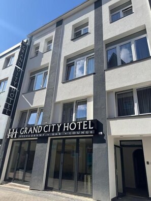 A multi-story hotel with a sign indicating it has a restaurant, bar, and lounge. - HI Skyline Hotel (Hannover)