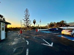 Ein Parkplatz mit Fahrbahnmarkierungen und einem Gebäude links.