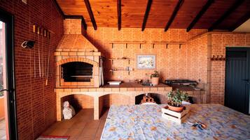 Una cocina con horno de ladrillo, vigas de madera y salpicadero de azulejos.