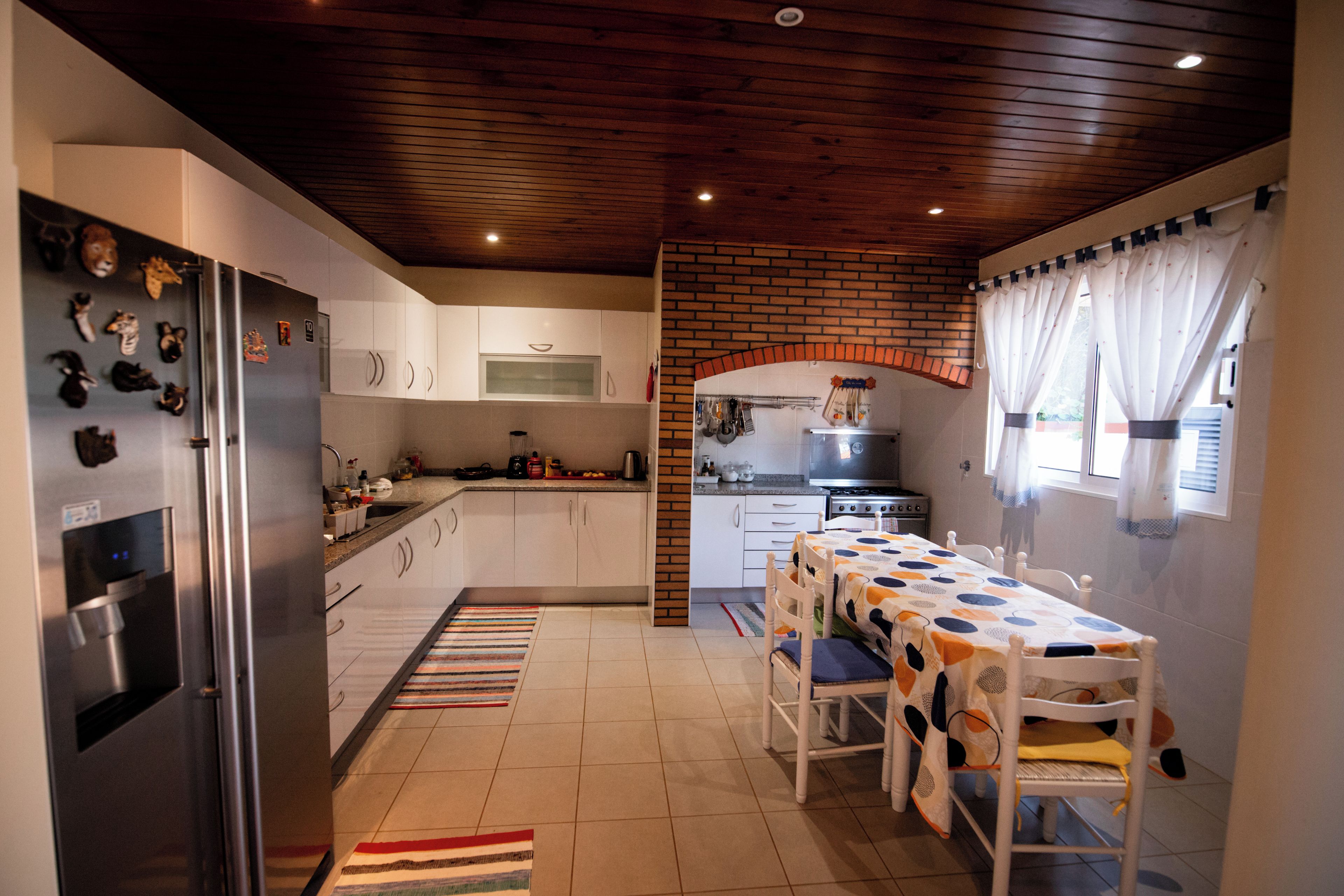 A modern kitchen with a refrigerator, stove, and dining area.