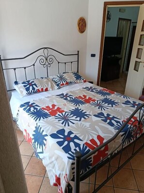 A bed with a metal frame and a patterned bedspread.