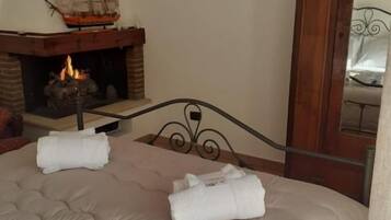Un dormitorio con cama, chimenea y espejo.