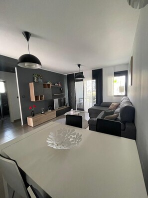 A modern living room with a dining area, grey walls, and contemporary furniture. - Groundfloor Oasis Beach VI Oasis Beach (Orihuela)