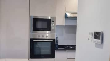 A modern kitchen with a built-in oven, microwave, and a gas stove.