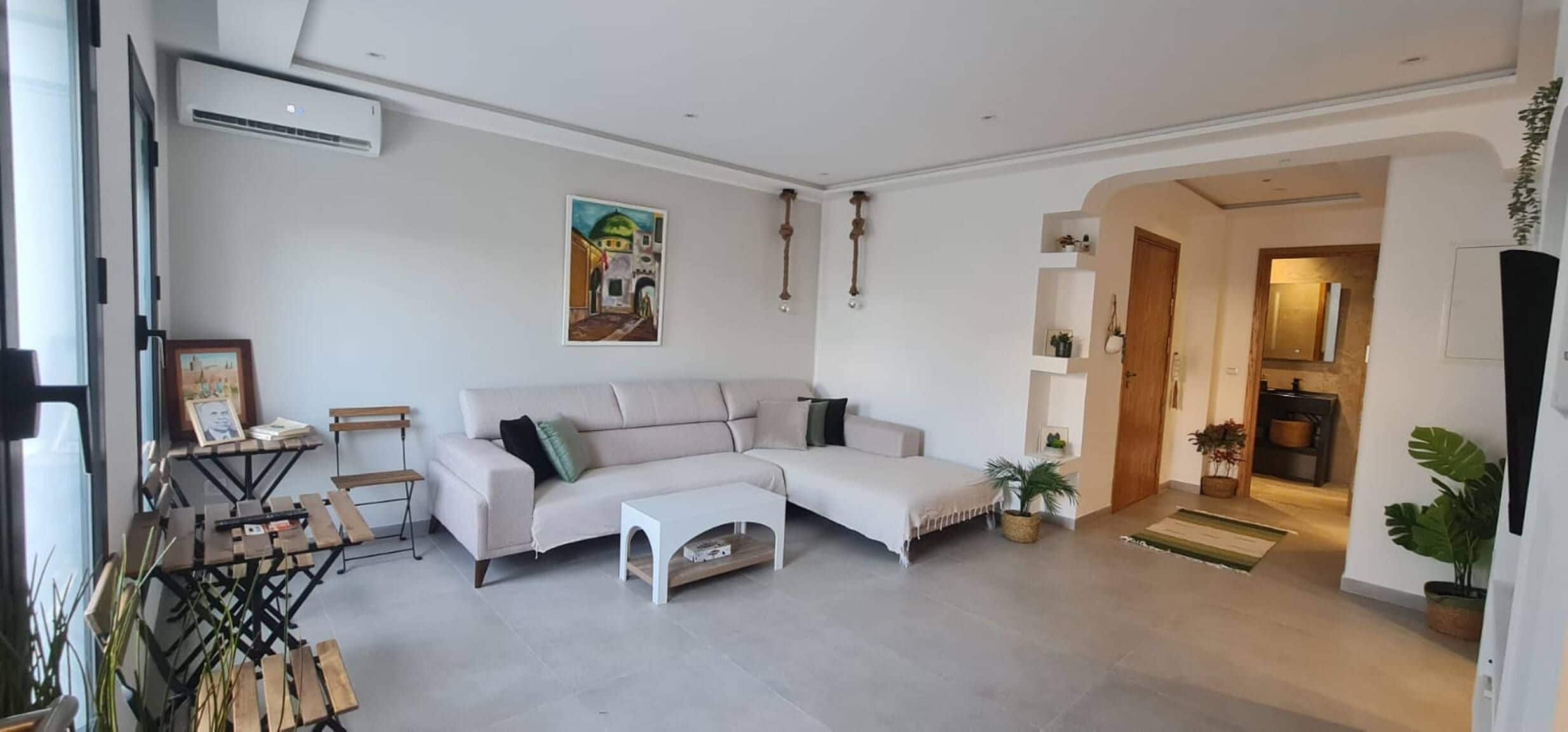 Una sala moderna con un sofá modular, una mesa de centro y un cuadro en la pared.