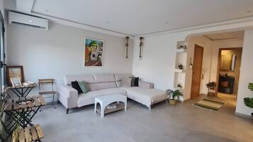 Una sala moderna con un sofá modular, una mesa de centro y un cuadro en la pared.
