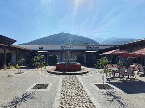 A courtyard with a fountain, outdoor seating, and a building with signage for 'Parador Santa Clara' and 'China City'. - CASA CAOBA - Modern colonial Villa, 3 volcano views rooftop & 4BR (Antigua)