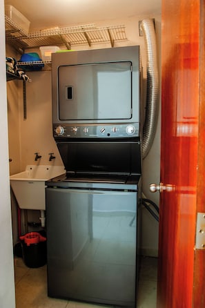 A compact kitchen with a built-in oven and a sink. - Ocean View Condo with Pool Near El Combate Beach (Boquerón)