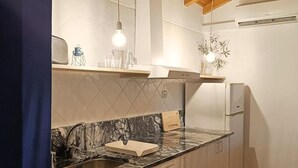 Eine Küche mit Holzboden, Marmorarbeitsplatte und integriertem Spülbecken.