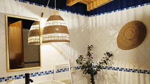 A bathroom with a wooden ceiling, a white sink, a mirror, and a blue-tiled wall. - Apartment 'Casa Medronheiro' with Mountain View, Wi-Fi and Air Conditioning (Melides)