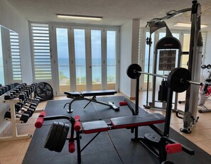 Une salle de sport équipée de matériel de musculation, d’un banc et d’haltères.