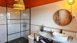 A bathroom with a glass shower enclosure, a white sink with a marble countertop, and a wooden ceiling. - Apartment 'Casa Laranjeira' with Mountain View, Wi-Fi and Air Conditioning (Melides)