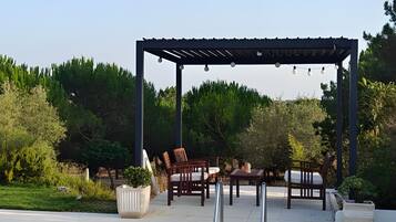 A swimming pool with a pergola and outdoor furniture.