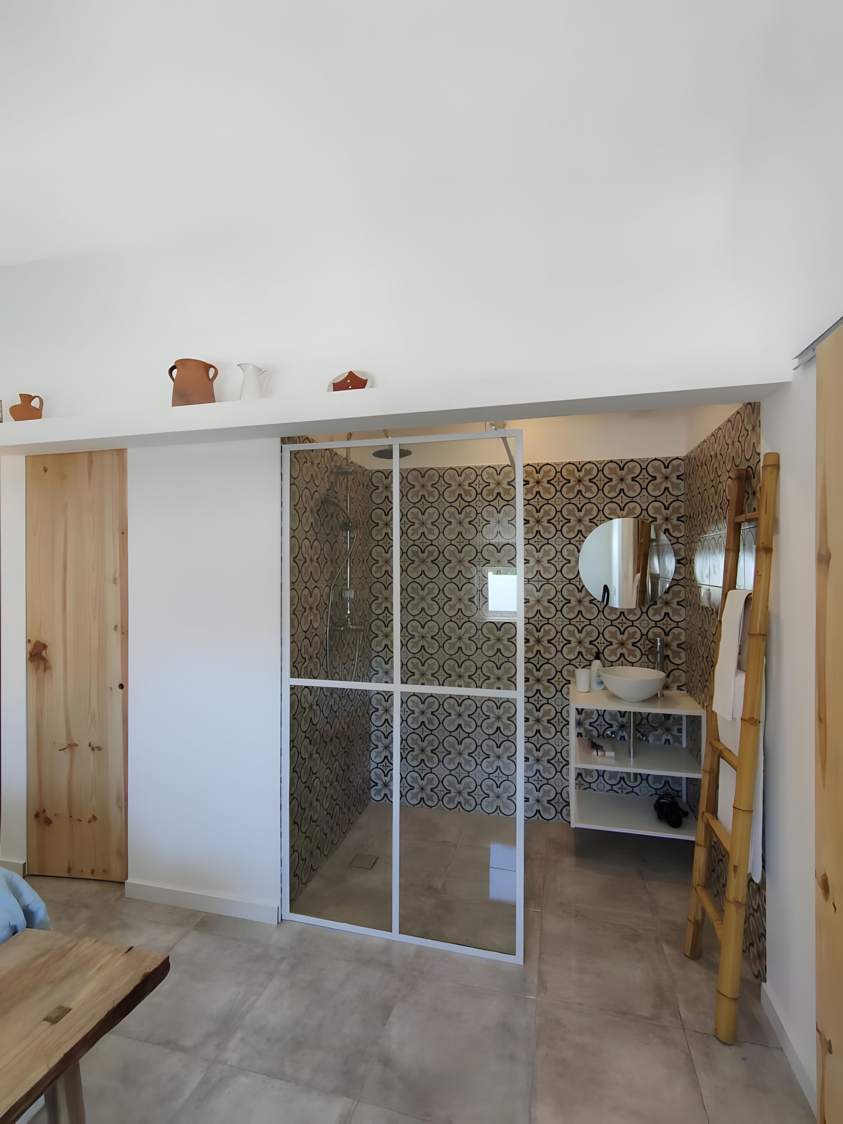 A bathroom with a shower, a sink, and a mirror.