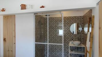 A bathroom with a shower, a sink, and a mirror.