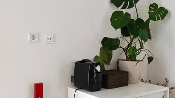 Et hvidt skab med en sort enhed og en potteplante ovenpå.