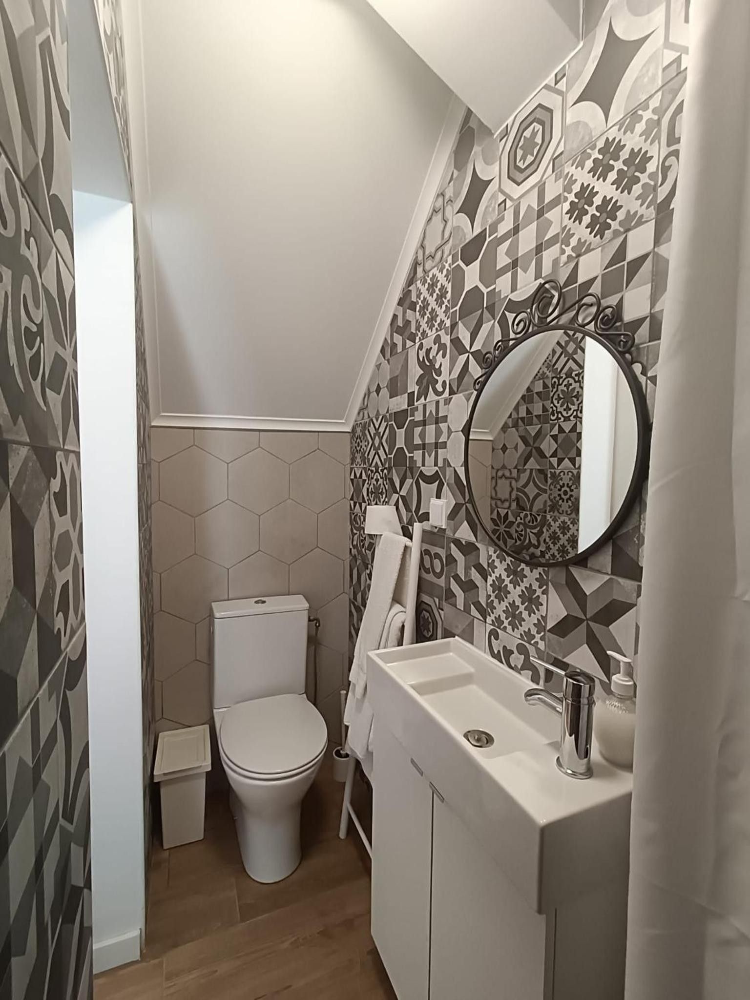 Un baño con inodoro, lavamanos y espejo.