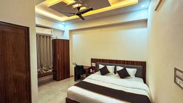 A bedroom with a bed, bedside tables, a wardrobe, and a ceiling fan.
