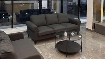A modern living room with a sectional sofa and a glass coffee table.