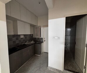 A kitchen with tiled backsplash, cabinets, and a countertop. - Suite Room Palette Hotel Whitefield (Bengaluru)